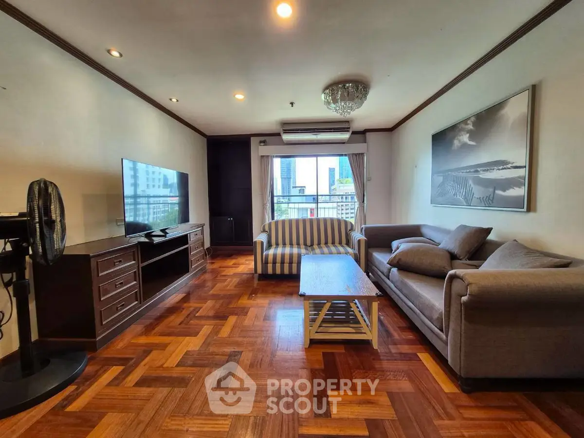 Spacious living room with elegant parquet flooring and modern furnishings in a high-rise apartment.