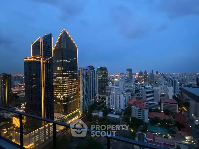 Stunning city skyline view from a high-rise balcony at dusk, showcasing illuminated skyscrapers.