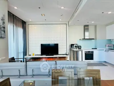 Modern open-layout living room with sleek kitchen, featuring contemporary furniture and stylish decor.