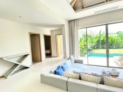 Spacious living room with pool view and modern decor, perfect for relaxation and entertaining.