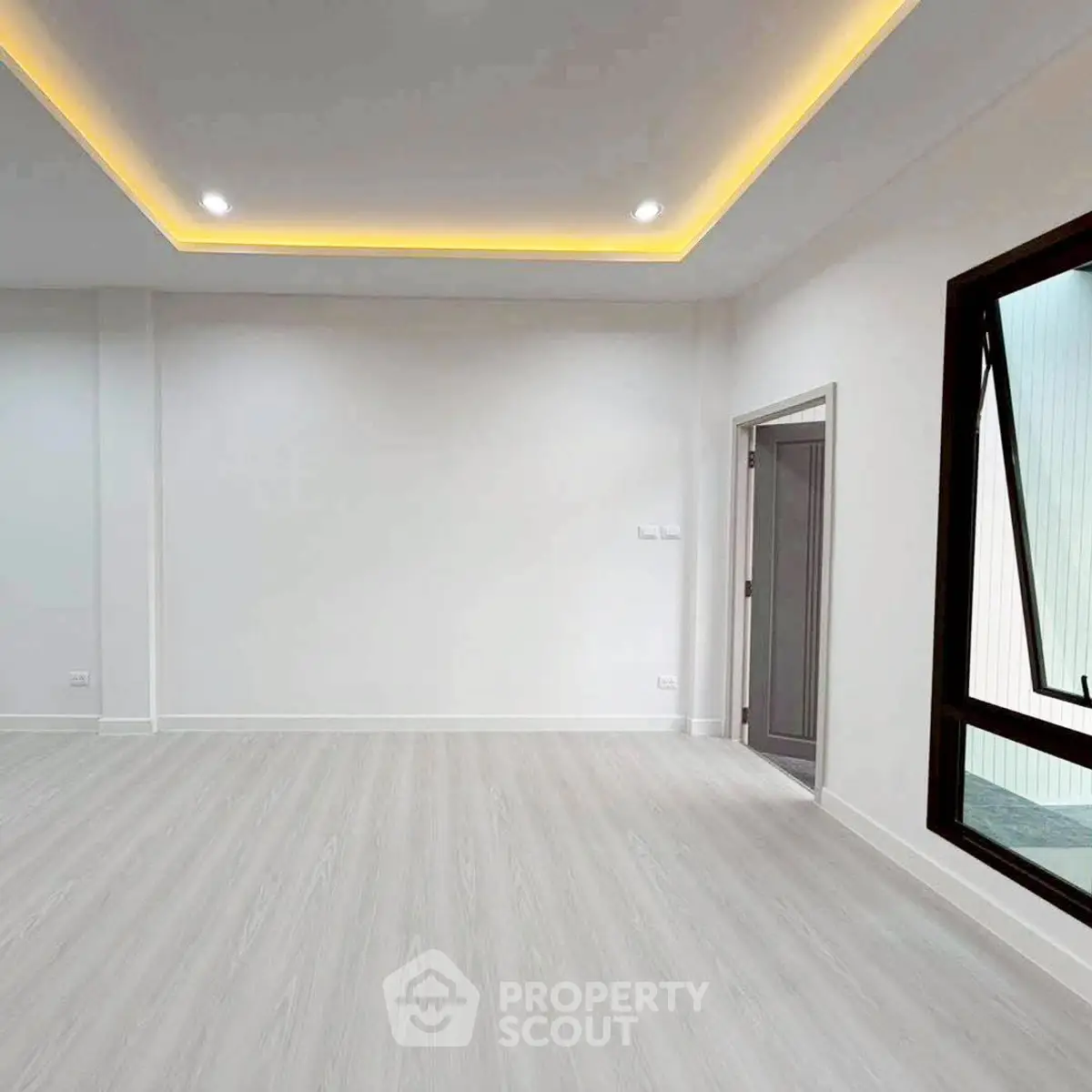 Spacious modern living room with recessed lighting and large window