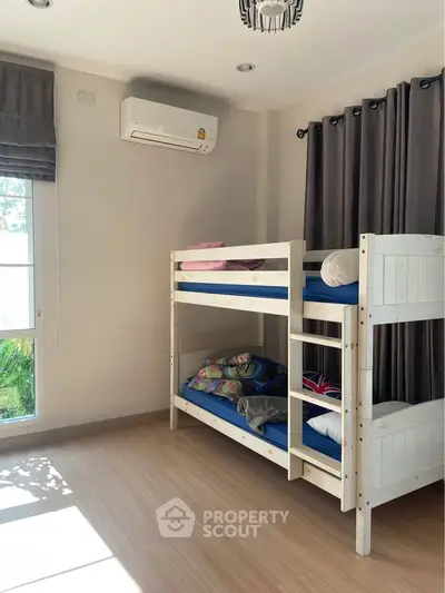Bright bedroom with bunk beds and air conditioning, perfect for a cozy and functional living space.
