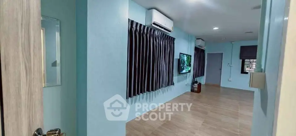 Spacious modern living room with air conditioning and sleek wooden flooring.