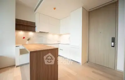 Modern kitchen with sleek cabinetry and wooden accents in a bright apartment.