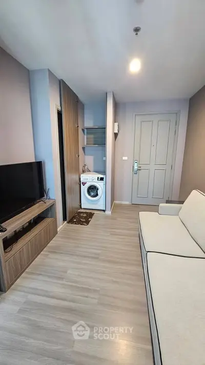 Modern living room with washing machine and sleek furniture in a stylish apartment.