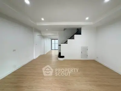 Spacious modern living room with sleek staircase and wooden flooring