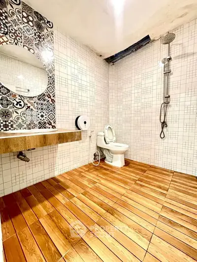 Stylish bathroom with wooden flooring and modern fixtures in a contemporary home.