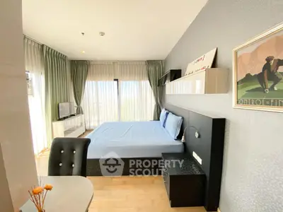 Spacious bedroom with modern decor and large windows offering natural light.