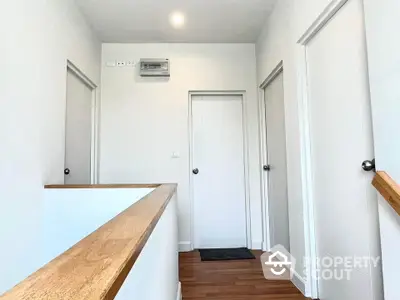 Modern hallway with wooden flooring and white doors in a contemporary home