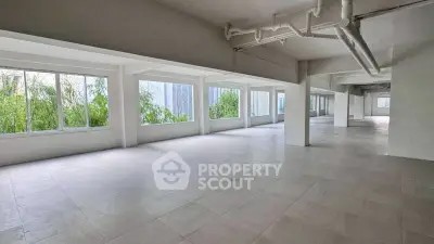 Spacious open-plan commercial space with large windows and natural light.