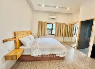 Spacious bedroom with modern design and large windows offering natural light.