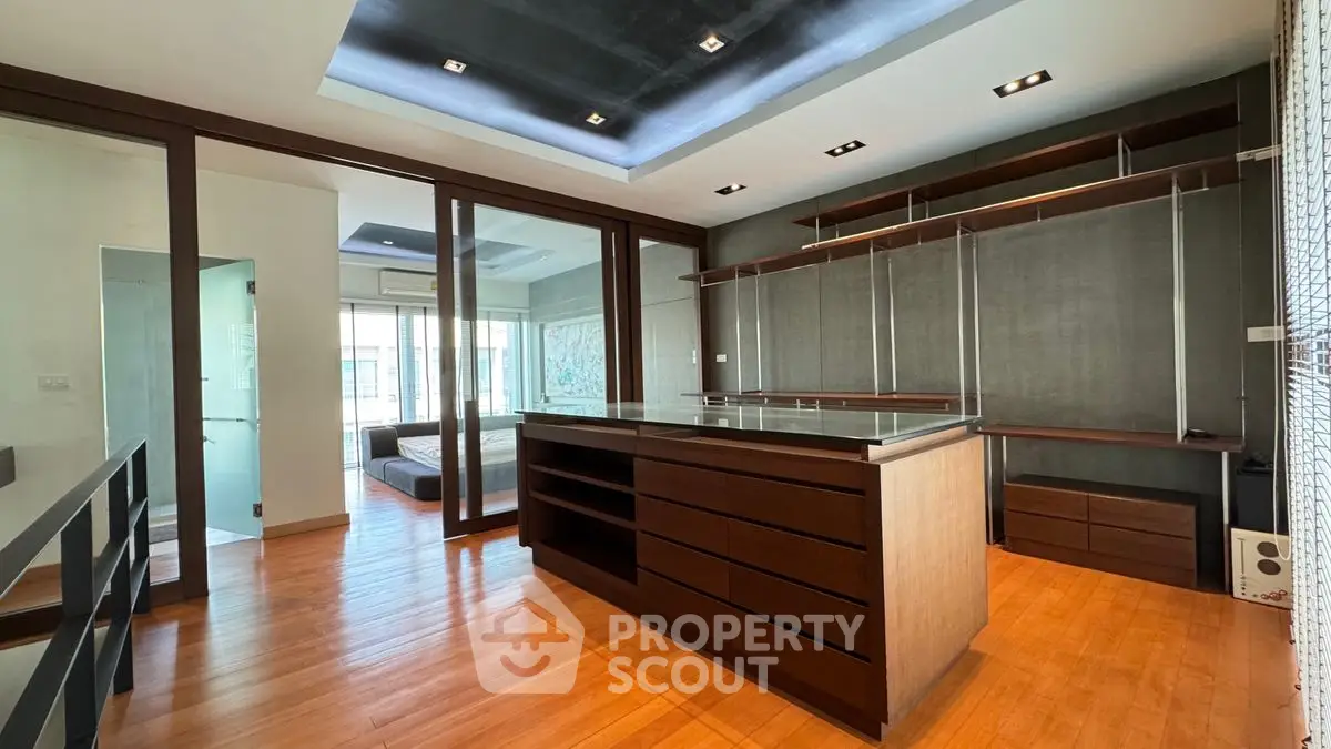 Spacious modern walk-in closet with sleek wooden finishes and ample storage space.
