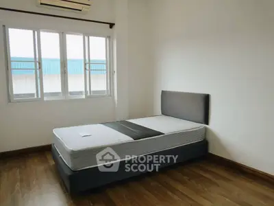 Spacious bedroom with large window and modern bed in a minimalist design.