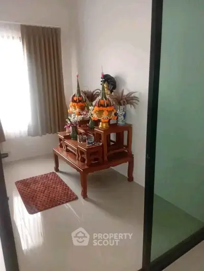 Cozy interior corner with decorative altar and natural light, perfect for serene living space.