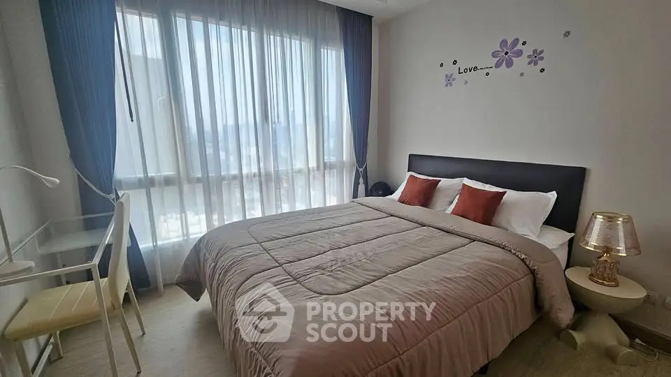 Cozy bedroom with large window and modern decor in a stylish apartment.