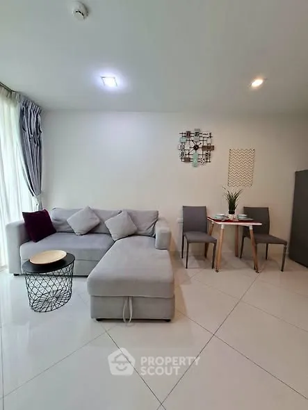 Modern living room with stylish gray sofa and chic dining area, perfect for urban living.