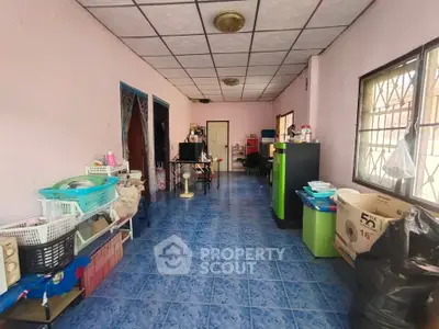Spacious interior with blue tiled floor and pink walls, ideal for versatile use.