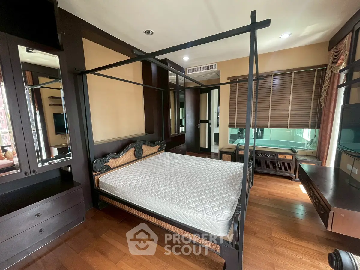Luxurious bedroom with elegant dark wood furniture and large windows