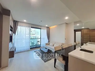 Modern living room with open kitchen and balcony view