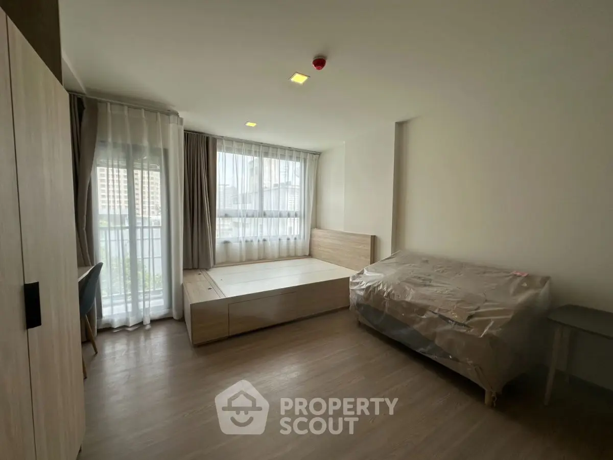 Spacious bedroom with modern furnishings and large windows for natural light.
