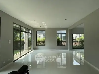 Spacious modern living room with large windows and glossy floors