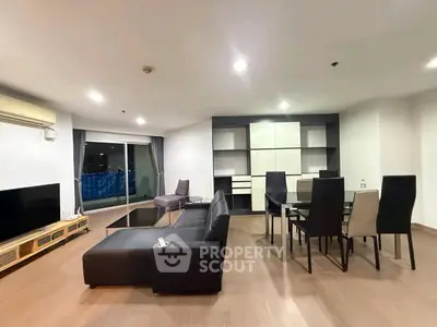 Spacious modern living room with sleek furniture and dining area, featuring large windows and elegant decor.