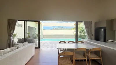 Spacious living room with pool view and modern dining area