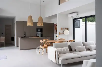 Modern open-plan living room and kitchen with stylish decor and natural light.