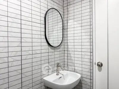 Modern bathroom with sleek white tiles and minimalist sink design.