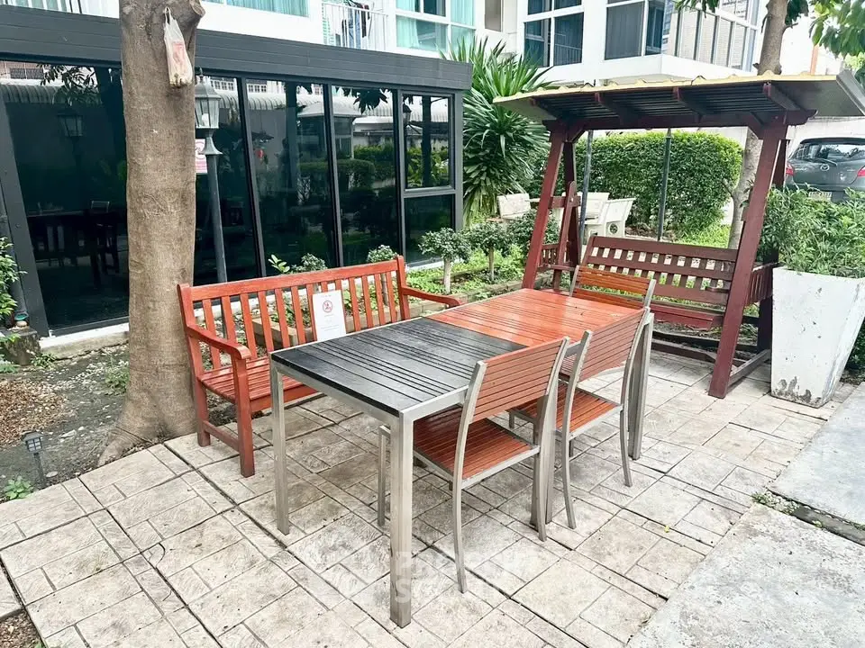 Charming outdoor patio with modern furniture in a lush garden setting, perfect for relaxation and entertaining.