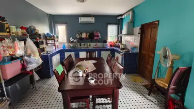 Charming kitchen with vibrant teal walls and spacious dining area