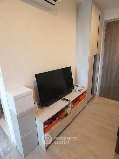 Modern living room with sleek TV stand and ample storage in a cozy apartment.
