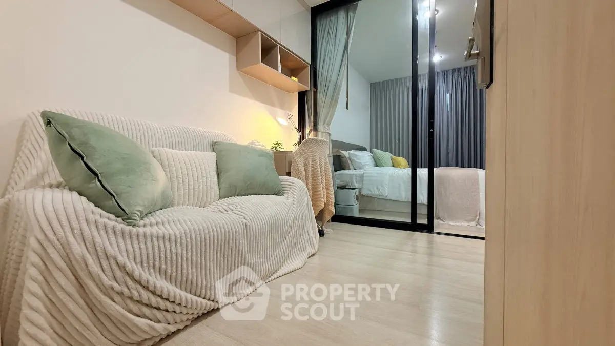Cozy modern living room with elegant decor and view into a stylish bedroom