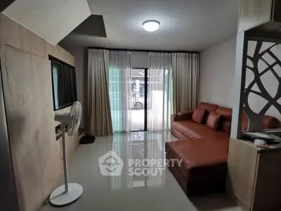 Modern living room with sleek design and natural light, featuring a stylish sofa and elegant curtains.