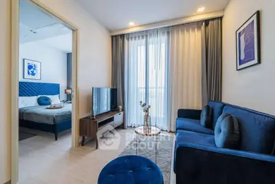 Modern living room with blue sofa and bedroom view in stylish apartment