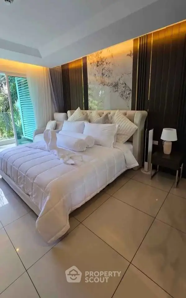 Luxurious bedroom with elegant decor and large windows offering natural light.