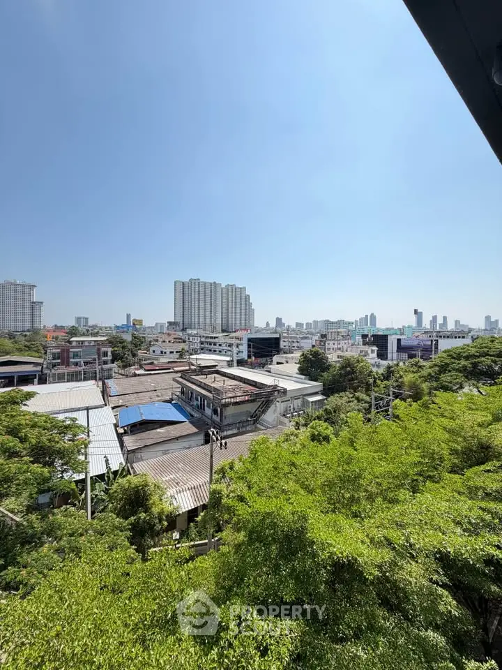 Stunning cityscape view with lush greenery and modern high-rise buildings under a clear blue sky.