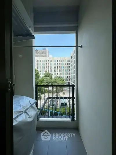Charming balcony view with urban landscape and lush greenery, perfect for relaxation and enjoying city life.