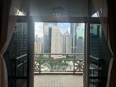 Stunning cityscape view from a high-rise balcony with glass doors and elegant curtains.