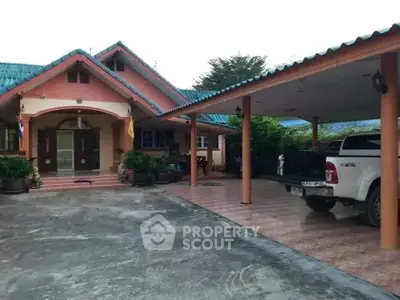 Charming suburban house with spacious driveway and covered parking area.