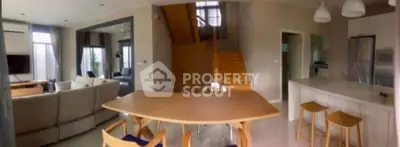 Spacious open-plan living and dining area with modern kitchen and stylish staircase.