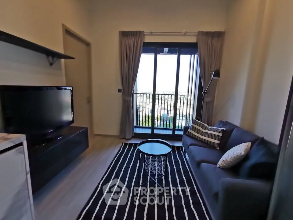Modern living room with balcony view, featuring sleek furniture and stylish decor.