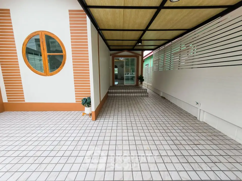Charming covered entrance with unique circular window and tiled flooring
