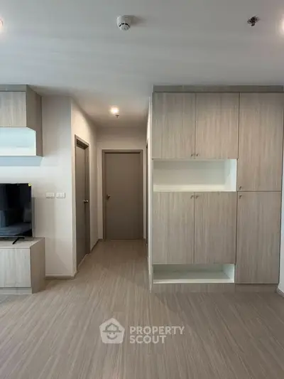 Modern apartment interior with sleek wooden cabinetry and neutral tones