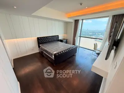 Luxurious bedroom with stunning city view and modern furnishings in high-rise apartment.