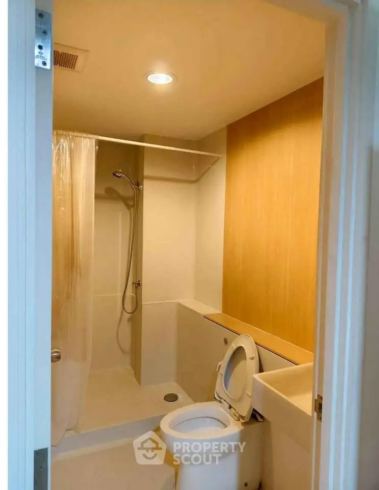 Modern bathroom with shower and wooden accent wall