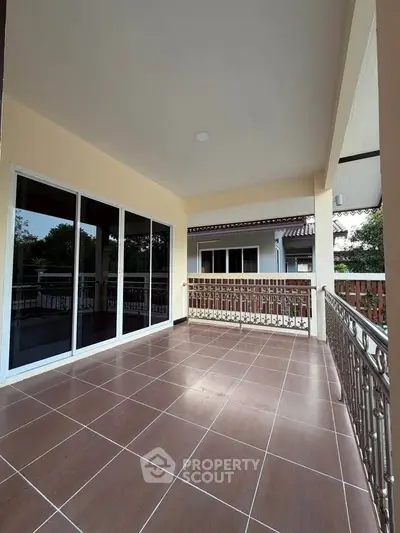 Spacious balcony with tiled flooring and elegant railing, perfect for outdoor relaxation.