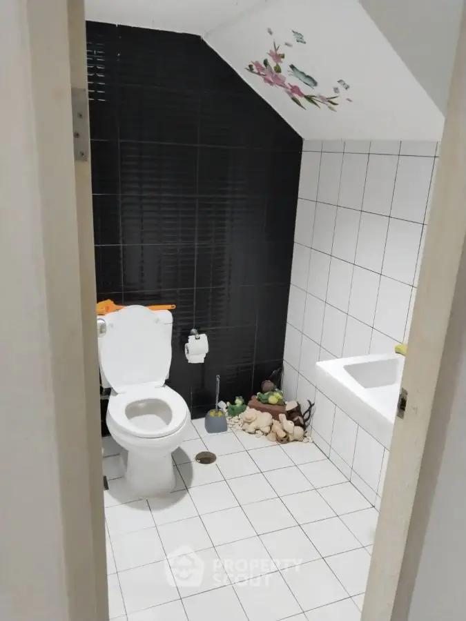 Charming bathroom with modern black and white tiles and decorative accents.