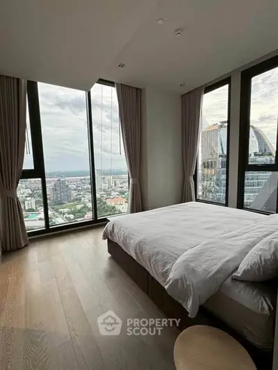 Luxurious bedroom with panoramic city views and floor-to-ceiling windows.