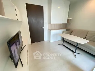 Modern living room with sleek furniture and wall-mounted TV in a cozy apartment.